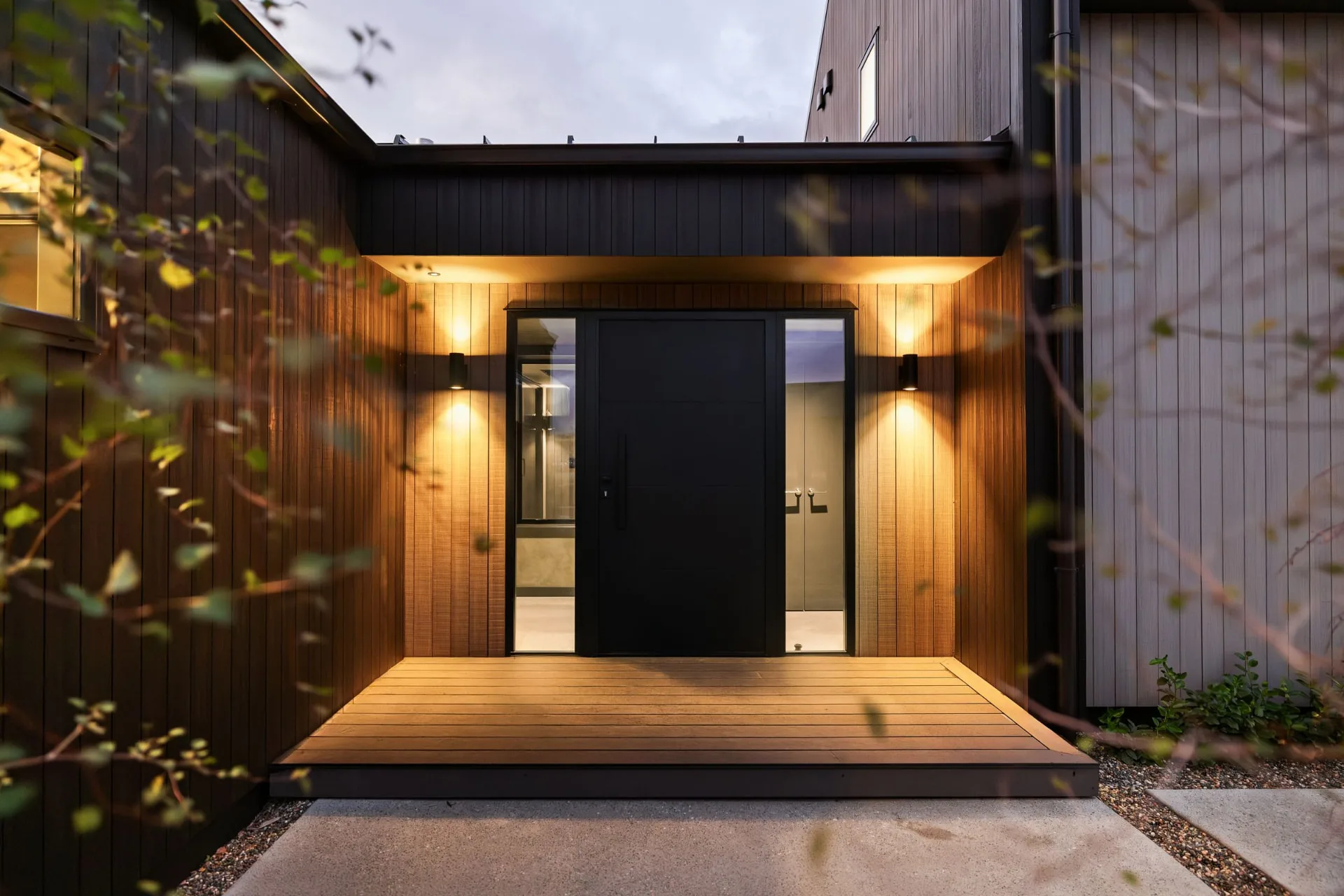 Sheltered front entrance with timber decking and warm wall lights, Drysdale Road
