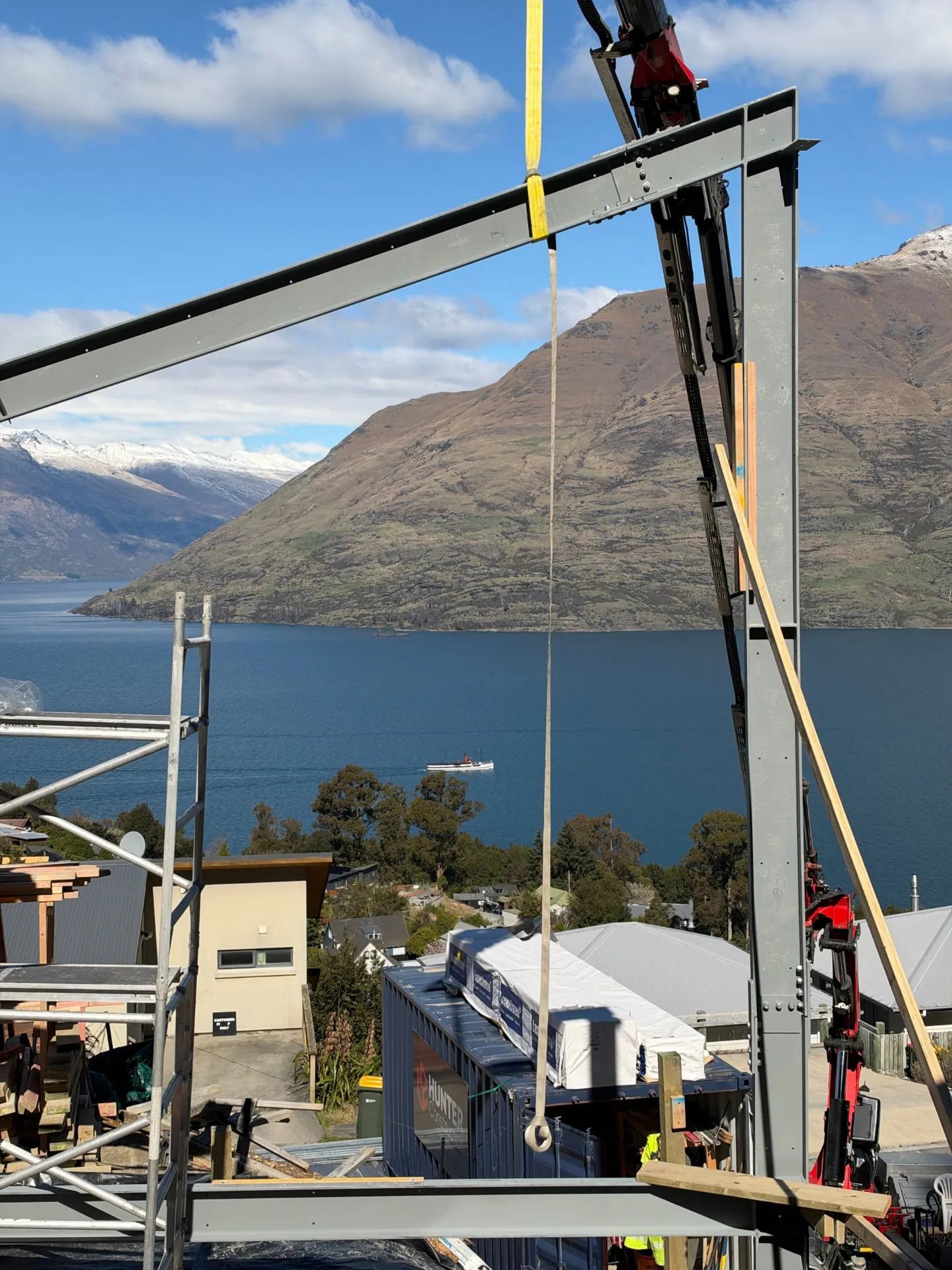 Te Tihi Villas steel portal frame with a crane strap, Lake Wakatipu and the TSS Earnslaw beyond