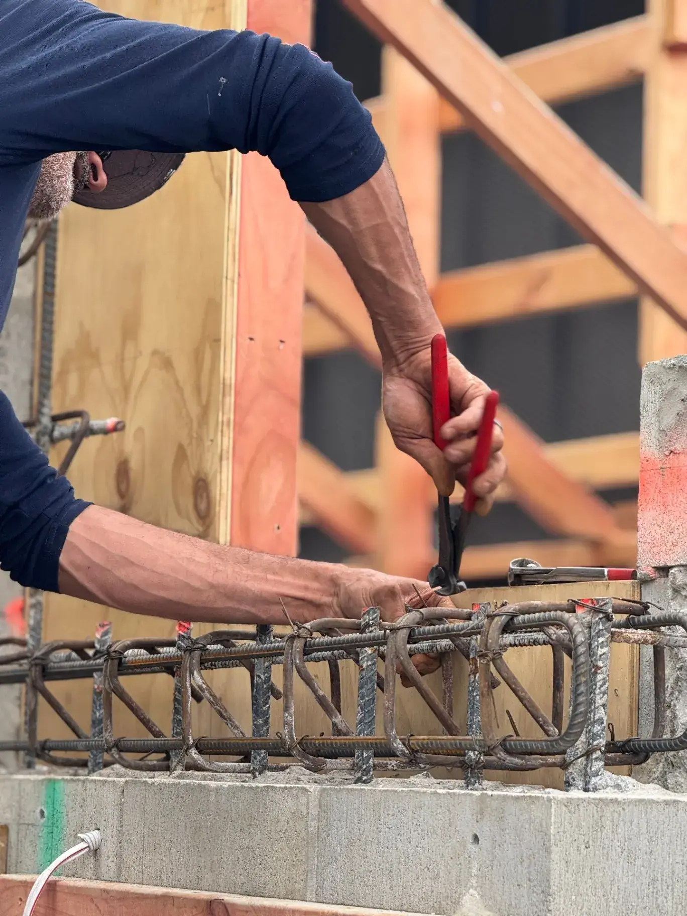 Hands tying reinforcing steel for concrete construction, Queenstown